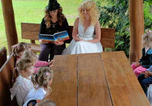 Dzieci słuchają bajki, którą czytam im ciocia Beata.